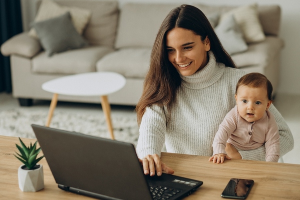 Mother-with-baby-daughter-working-on-computer-from-home